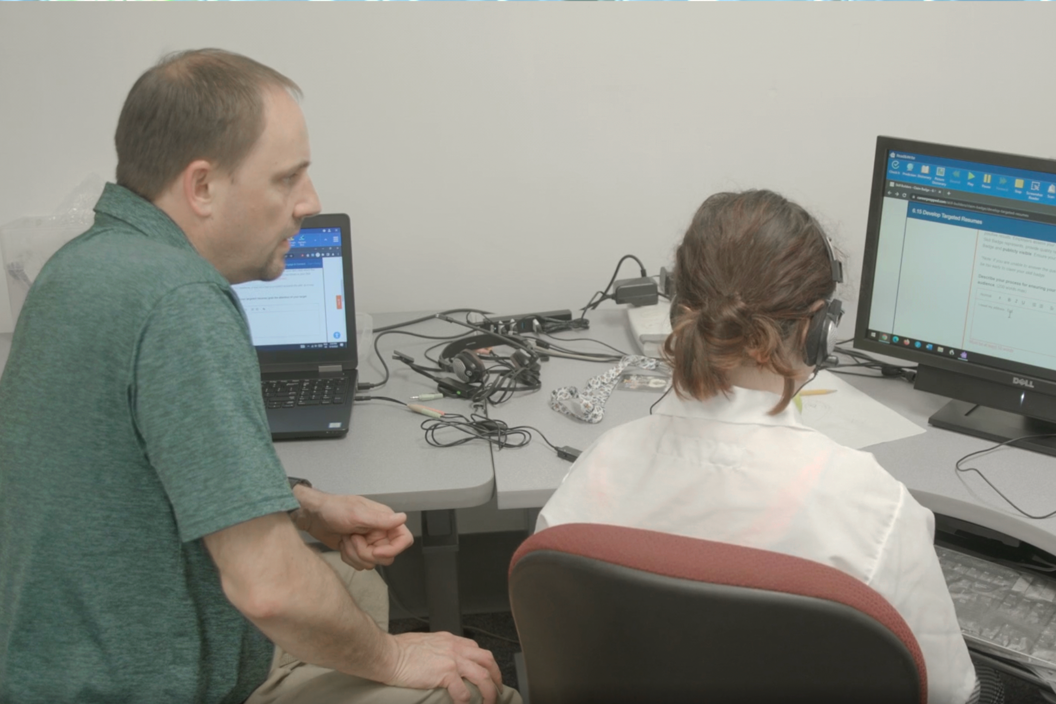 Instructor helping student on computer